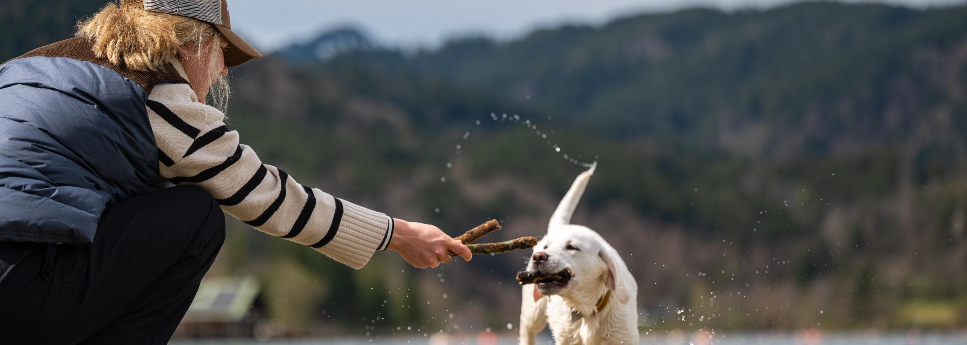 Selina G. mit Hündin Nala (weißer Labrador) an der Isar