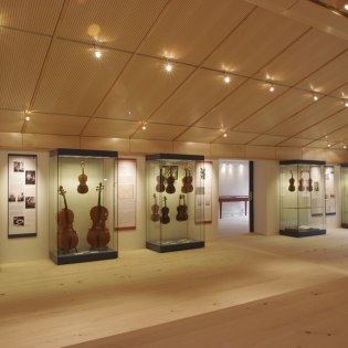 Vitrinen mit Schaustücken im Veranstaltungsraum des Geigenbaumuseums, © Alpenwelt Karwendel | Pfisterer