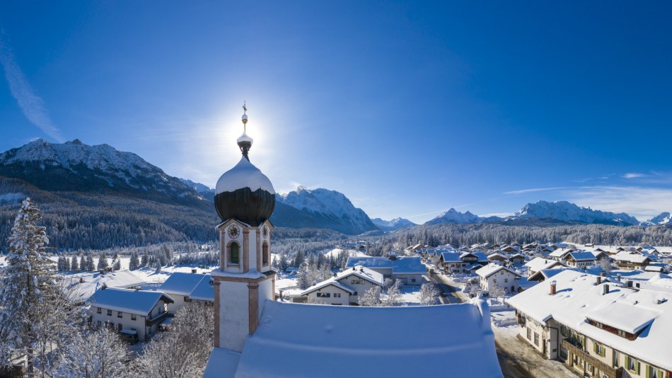 Winter in Krün - Kirchturm mit Bergpanorama von Seinskopf bis Waxensteine., © Alpenwelt Karwendel | Kriner & Weiermann